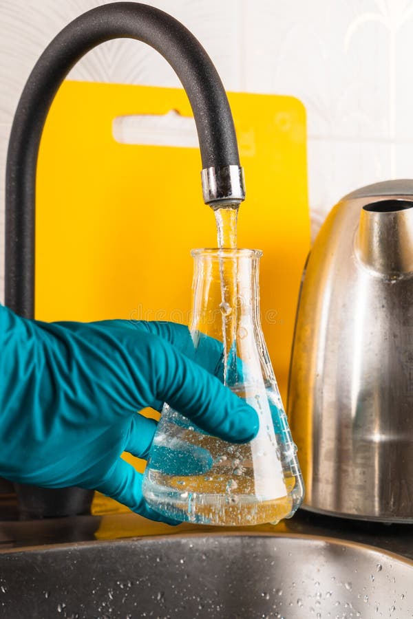 L'eau Du Robinet Se Jette Dans Une Fiole De Verre Image stock