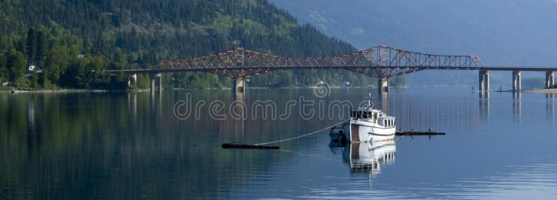 A panoramic image of a small fishing boat moored in the west arm of Kootenay Lake in Nelson, BC Canada. A panoramic image of a small fishing boat moored in the west arm of Kootenay Lake in Nelson, BC Canada.