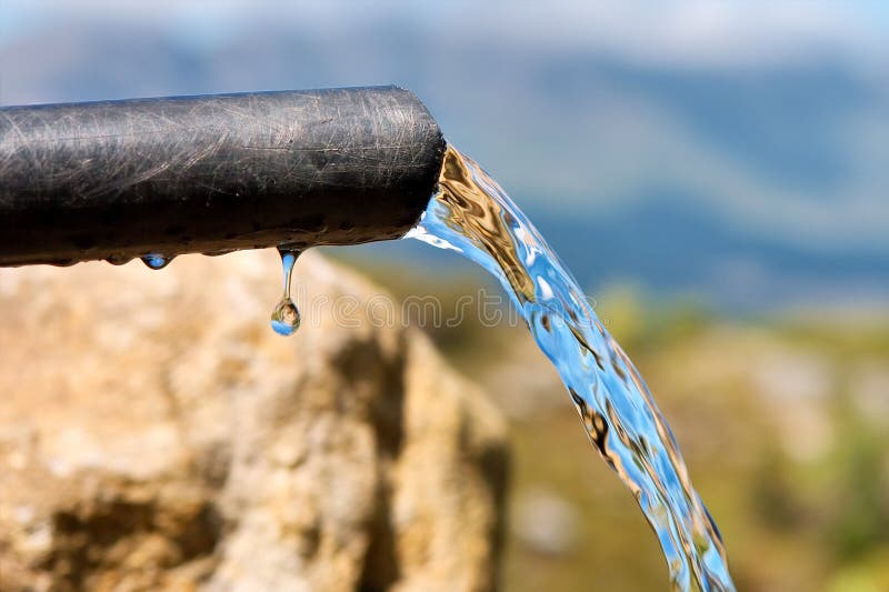 De l'eau pure s'écoule et goutte d'un tuyau photos libres de droits