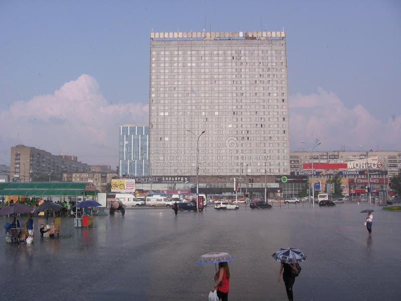 L'edificio alto nelle persone del centro commerciale della città cammina sotto la pioggia