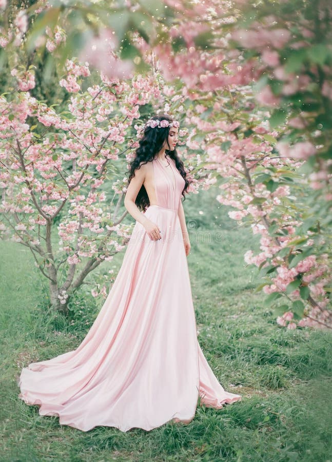 L'elfo incredibile e delicato in un lussuoso, dentella delicatamente le passeggiate del vestito in primavera, sakura ed il frutte immagine stock libera da diritti L'elfo incredibile e delicato in un lussuoso, dentella delicatamente le passeggiate del vestito in primavera, sakura ed il frutte immagine stock libera da diritti