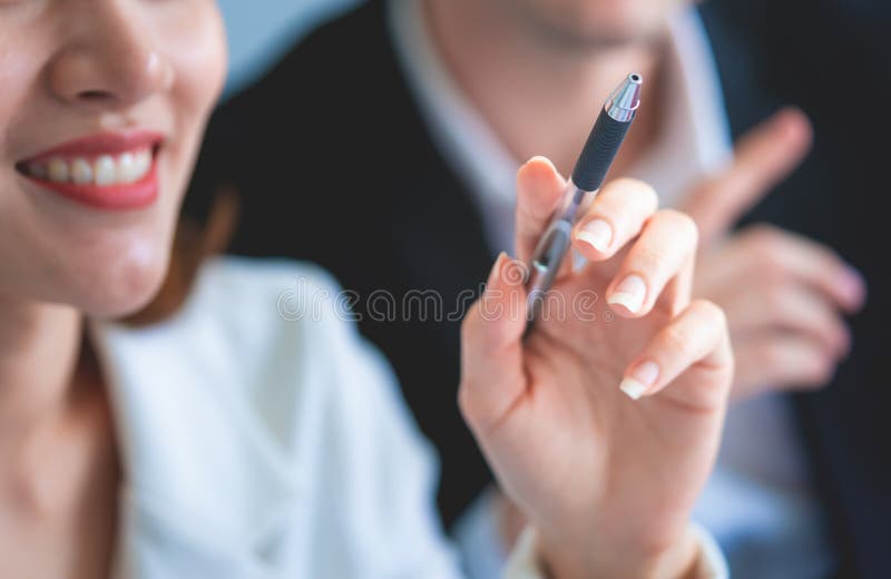L'employé de bureau féminin hodling le stylo en se réunissant photo stock L'employé de bureau féminin hodling le stylo en se réunissant photo stock
