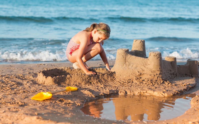 L'enfant construit le pâté de sable sur la plage photographie stock libre de droits