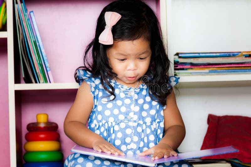 L'enfant a lu, petite fille mignonne lisant un livre photos stock L'enfant a lu, petite fille mignonne lisant un livre photos stock