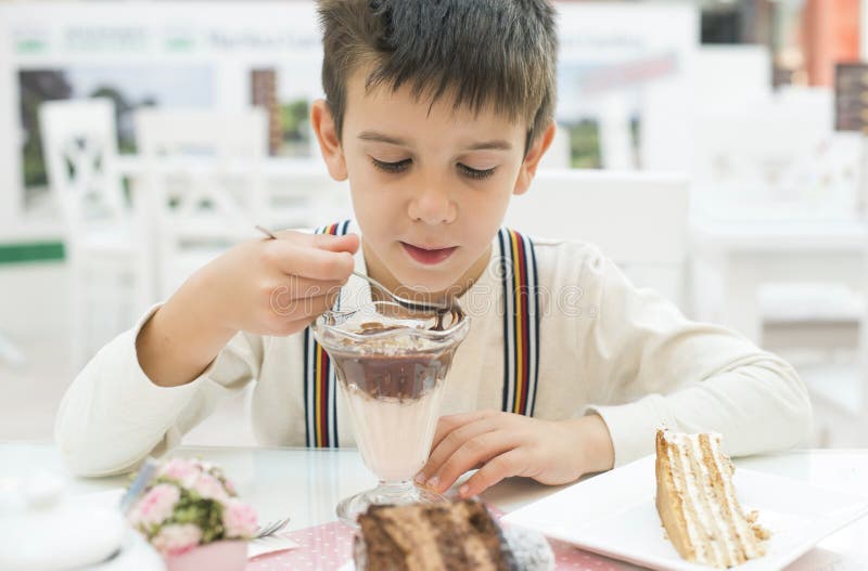 L'enfant mangent la secousse de choco de lait photographie stock L'enfant mangent la secousse de choco de lait photographie stock