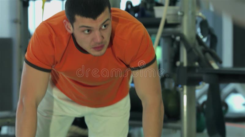 L'entraîneur de conditionnement physique fait un exercice abdominal à un jeune homme banque de vidéos