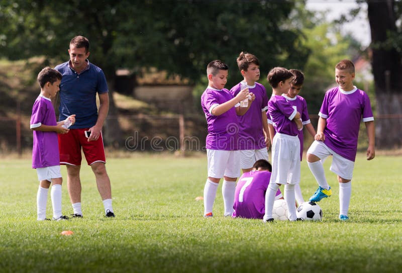 L'entraîneur donne des conseils aux footballeurs sur le match de football photo libre de droits L'entraîneur donne des conseils aux footballeurs sur le match de football photo libre de droits