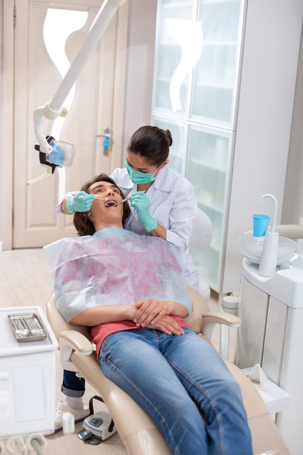 L'esame femminile attento di medico pazienti giovani dice immagini stock L'esame femminile attento di medico pazienti giovani dice immagini stock