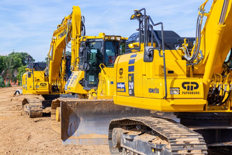L'escavatore di KOMATSU ed altri veicoli della costruzione sta su un cantiere fotografie stock L'escavatore di KOMATSU ed altri veicoli della costruzione sta su un cantiere fotografie stock