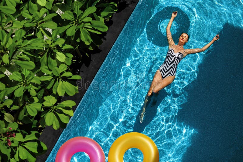 L'estate si distende Donna che galleggia, acqua della piscina Feste di estate immagine stock L'estate si distende Donna che galleggia, acqua della piscina Feste di estate immagine stock