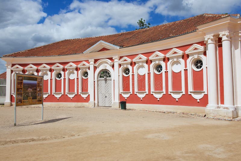 L'esterno del rosso ha dipinto le stalle che costruiscono accanto al palazzo di Rundale in Pilsrundale, Lettonia immagine stock L'esterno del rosso ha dipinto le stalle che costruiscono accanto al palazzo di Rundale in Pilsrundale, Lettonia immagine stock