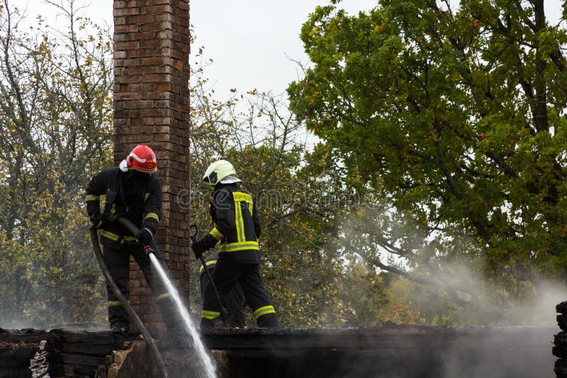 L'estinzione del fuoco ha distrutto la casa del villaggio sul quinto ottobre fotografia stock L'estinzione del fuoco ha distrutto la casa del villaggio sul quinto ottobre fotografia stock