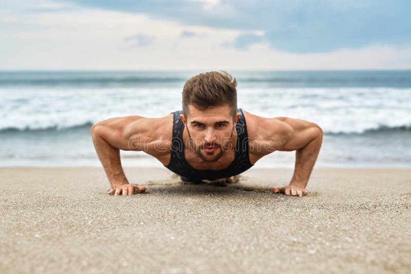 L'exercice d'homme, faisant soulèvent des exercices sur la plage Séance d'entraînement de forme physique photo libre de droits L'exercice d'homme, faisant soulèvent des exercices sur la plage Séance d'entraînement de forme physique photo libre de droits