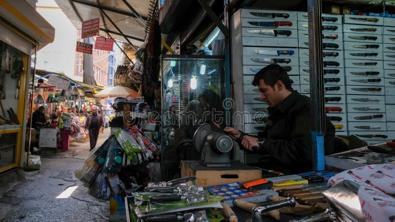 L'homme affile le couteau au bazar images libres de droits L'homme affile le couteau au bazar images libres de droits