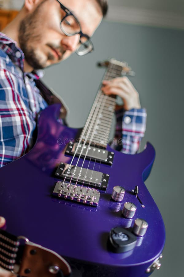 L'homme apprennent jouer la guitare électrique à la maison photos libres de droits L'homme apprennent jouer la guitare électrique à la maison photos libres de droits