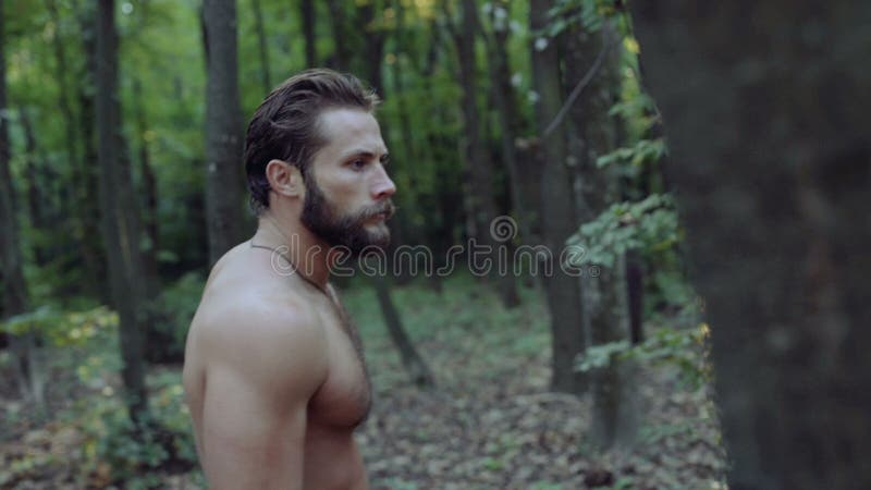L'homme barbu bel marche avec la hache dans la forêt 4K