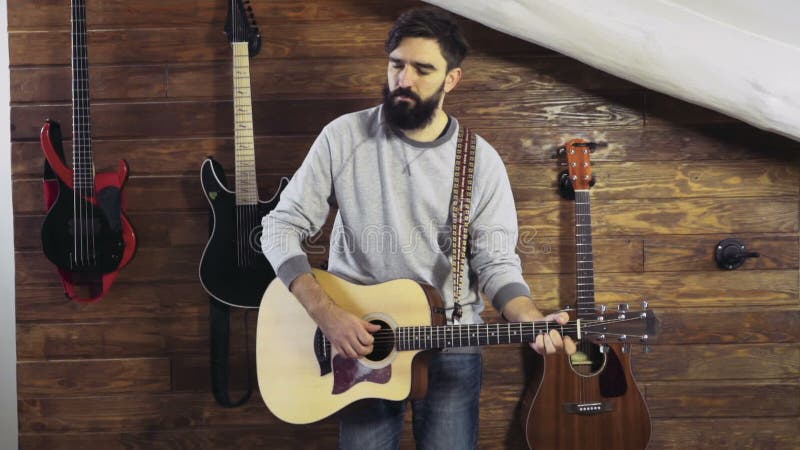 L'homme barbu a fermé ses yeux pour apprécier la guitare jouant le mouvement lent