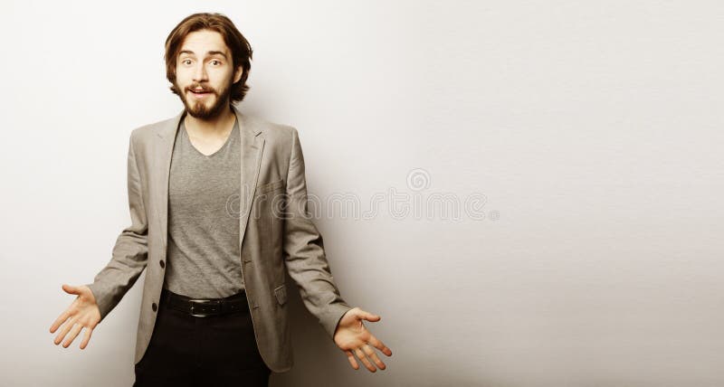 L'homme barbu voit quelque chose incroyable qui le fait heureux et excité, fait des gestes activement, exprime le choc agréable photo stock L'homme barbu voit quelque chose incroyable qui le fait heureux et excité, fait des gestes activement, exprime le choc agréable photo stock