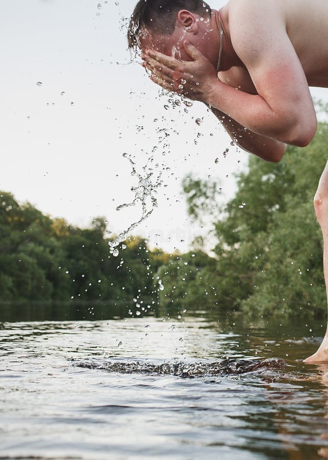 L'homme caucasien se lave avec la rivière de forêt d'eau propre photos stock L'homme caucasien se lave avec la rivière de forêt d'eau propre photos stock