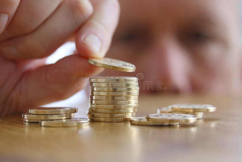 L'homme compte ses pièces de monnaie sur une table Plan rapproché de main mettant une pièce de monnaie à la pile de pièces d'or photo libre de droits L'homme compte ses pièces de monnaie sur une table Plan rapproché de main mettant une pièce de monnaie à la pile de pièces d'or photo libre de droits