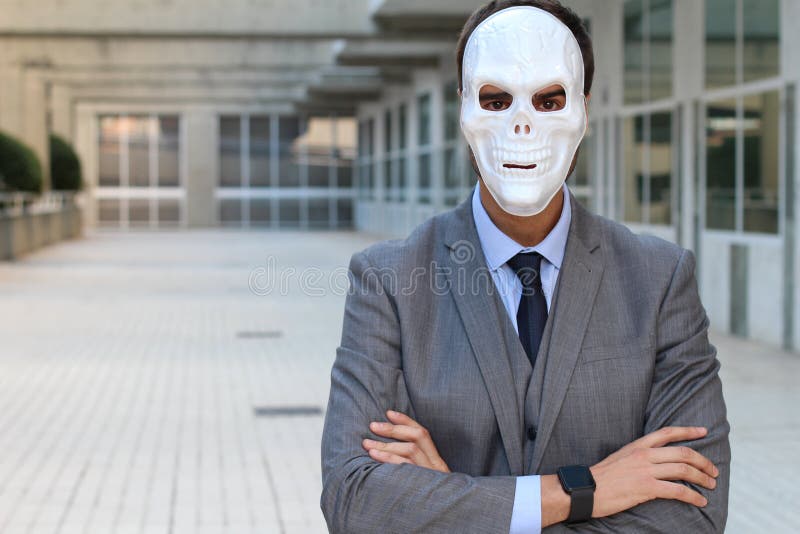 L'homme d'affaires avec des bras a croisé porter un masque horrible photo stock L'homme d'affaires avec des bras a croisé porter un masque horrible photo stock