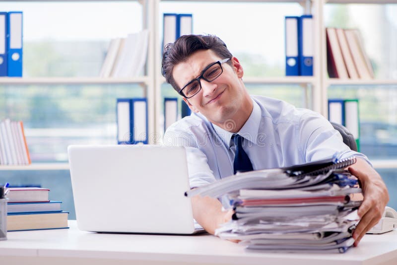 L'homme d'affaires avec des écritures excessives de travail fonctionnant dans le bureau photos stock L'homme d'affaires avec des écritures excessives de travail fonctionnant dans le bureau photos stock