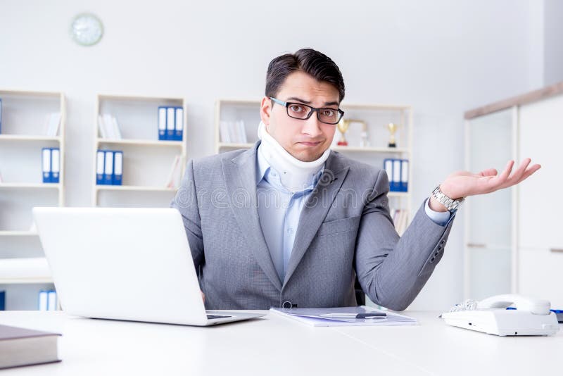 L'homme d'affaires avec la blessure de cou fonctionnant dans le bureau photos libres de droits L'homme d'affaires avec la blessure de cou fonctionnant dans le bureau photos libres de droits