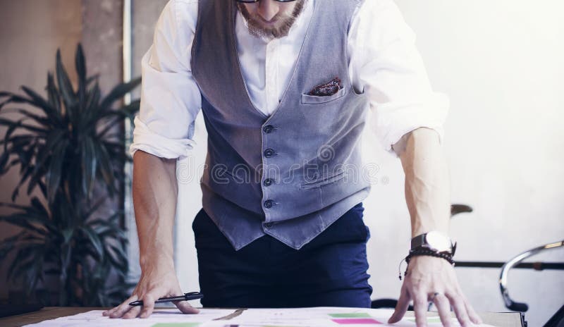 L'homme d'affaires barbu Analyzes Business Plan de plan rapproché documente le lieu de travail moderne Jeune homme travaillant le photo stock L'homme d'affaires barbu Analyzes Business Plan de plan rapproché documente le lieu de travail moderne Jeune homme travaillant le photo stock