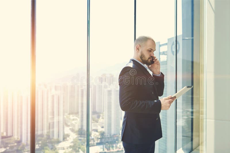 L'homme d'affaires est fenêtre proche debout avec l'espace de copie photographie stock L'homme d'affaires est fenêtre proche debout avec l'espace de copie photographie stock