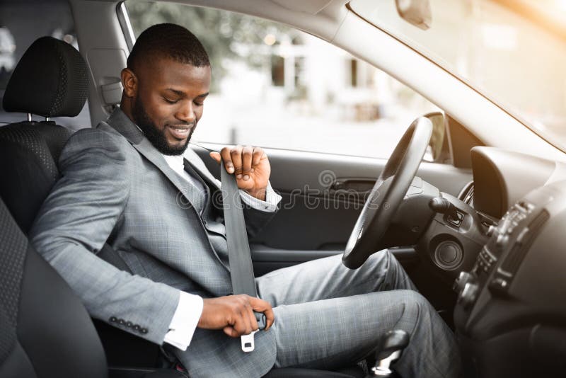 L'homme d'affaires noir bel attachent une ceinture de sécurité dans sa voiture