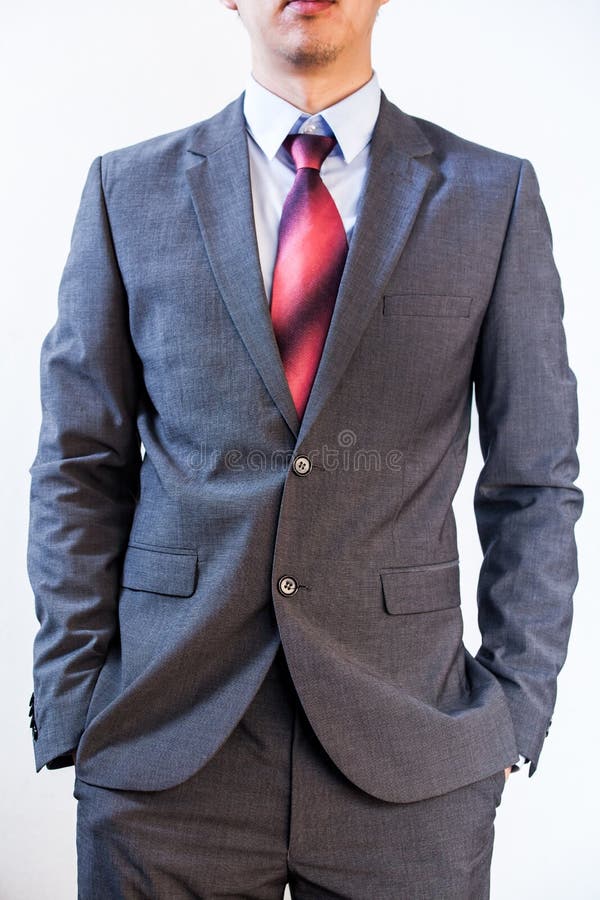 L'homme d'affaires tenant ses mains dans la poche sur le blanc a isolé le fond image stock L'homme d'affaires tenant ses mains dans la poche sur le blanc a isolé le fond image stock