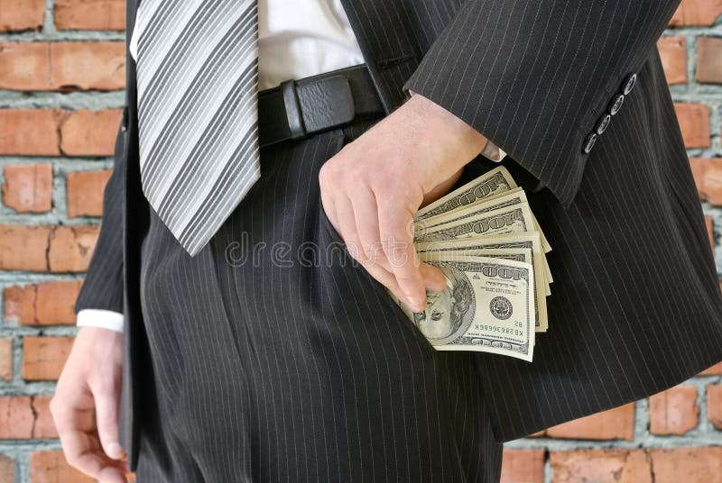 L'homme dans un costume a mis l'argent dans votre poche photo libre de droits L'homme dans un costume a mis l'argent dans votre poche photo libre de droits