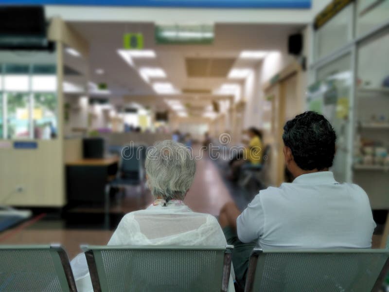 L'homme de dame âgée et d'adulte s'asseyent sur l'attente inoxydable grise de chaise médicale et les services de santé à l'hôpita photo libre de droits L'homme de dame âgée et d'adulte s'asseyent sur l'attente inoxydable grise de chaise médicale et les services de santé à l'hôpita photo libre de droits