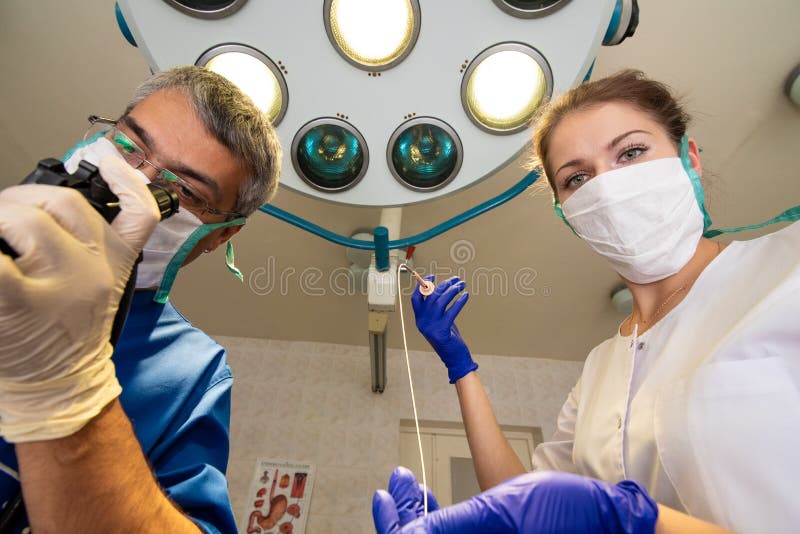 L'homme et une femme dans les masques se tiennent se faisants face et tenants les instruments médicaux dans leurs mains photos libres de droits L'homme et une femme dans les masques se tiennent se faisants face et tenants les instruments médicaux dans leurs mains photos libres de droits