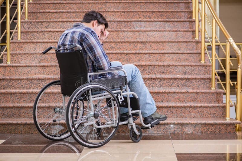 L'homme handicapé sur le fauteuil roulant ayant des ennuis avec des escaliers