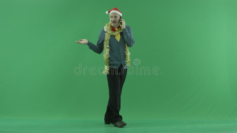 L'homme heureux parle au-dessus du smartphone sur Noël, fond vert de clé de chroma