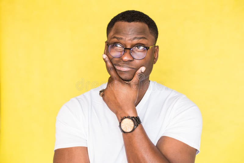 L'homme incertain embarrass? d'Afro-am?ricain avec des verres tient son menton et pince ses l?vres, regarde incr?dule, essaye images libres de droits L'homme incertain embarrass? d'Afro-am?ricain avec des verres tient son menton et pince ses l?vres, regarde incr?dule, essaye images libres de droits