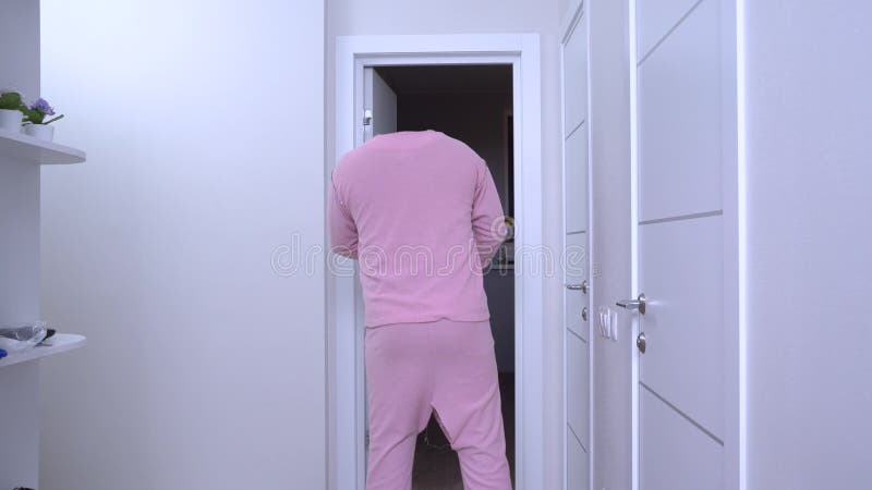 L'homme invisible dans un pyjama roses emprunte le corridor de l'appartement à la chambre noire Effets spéciaux pour tirer la sci