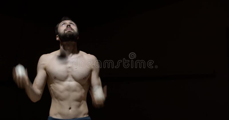 L'homme musculaire torse nu beaucoup de jonglage boules formant 4k clips vidéos
