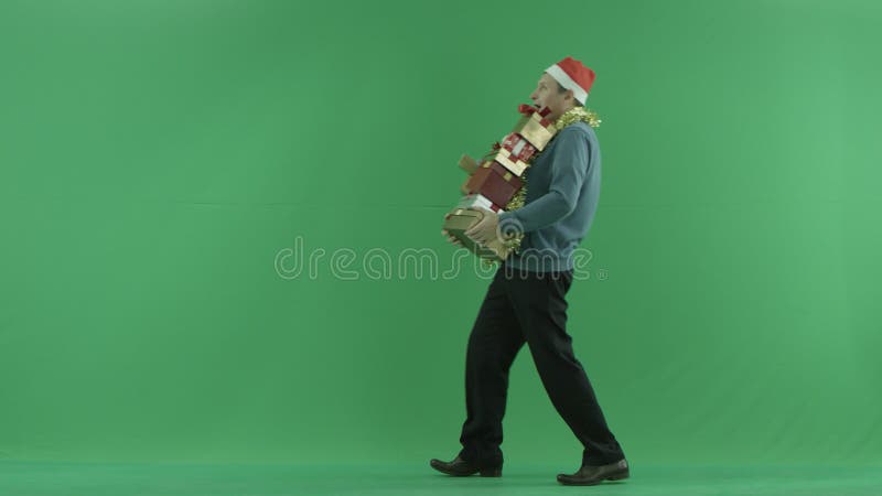 L'homme mûr marche avec des cadeaux de Noël, fond vert de clé de chroma