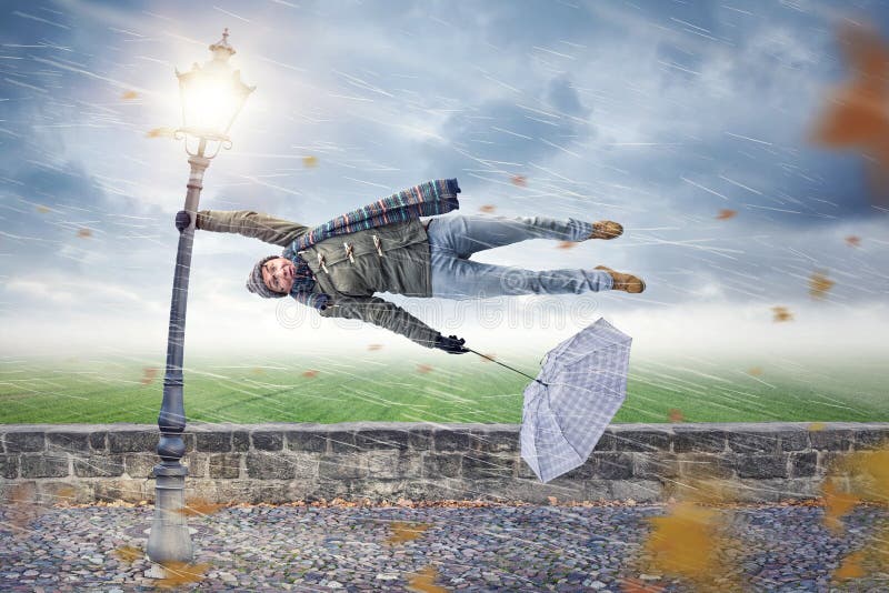 L'homme obtient soufflé loin par une tempête photos libres de droits L'homme obtient soufflé loin par une tempête photos libres de droits