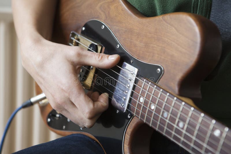 L'homme pianote la corde sur la guitare photos stock L'homme pianote la corde sur la guitare photos stock