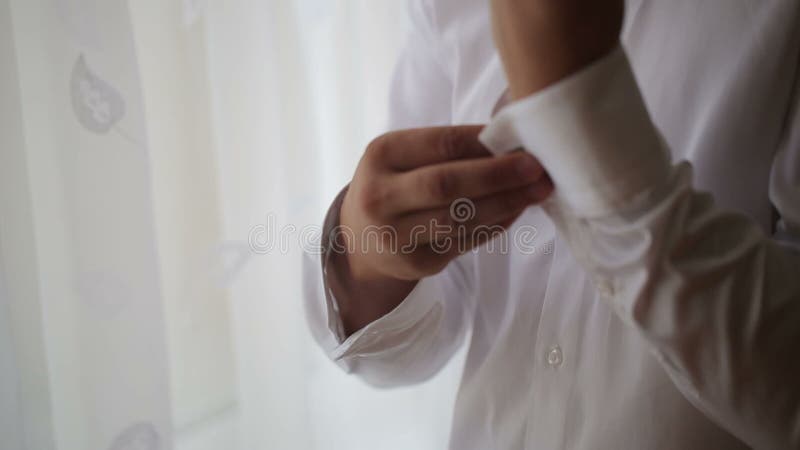 L'homme porte la chemise et les boutons de manchette blancs