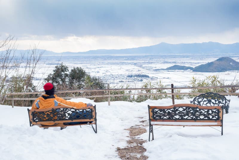L'homme s'asseyent sur le fauteuil par derrière dessus la montagne de Hachiman images stock L'homme s'asseyent sur le fauteuil par derrière dessus la montagne de Hachiman images stock
