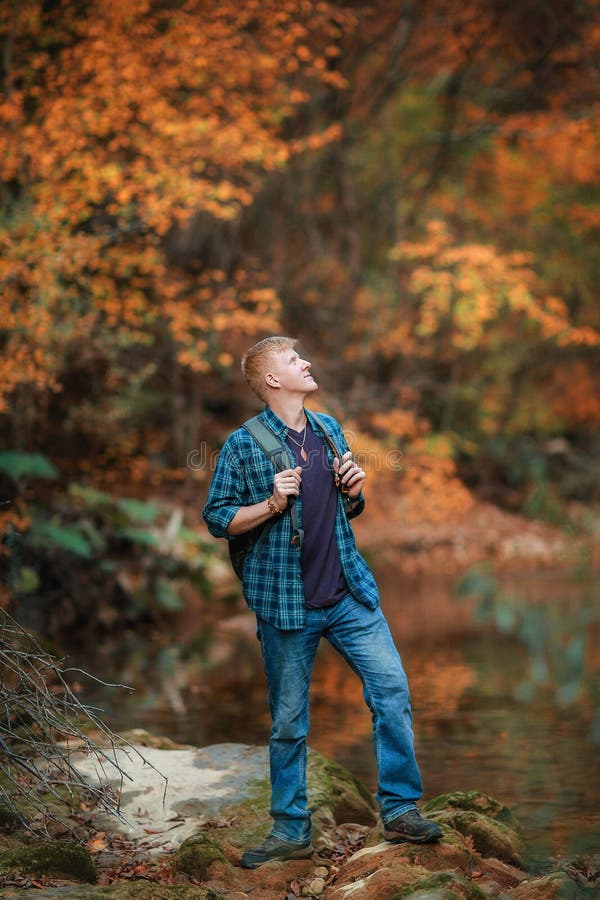 L'homme se tient pr?s du courant de montagne en automne image libre de droits L'homme se tient pr?s du courant de montagne en automne image libre de droits