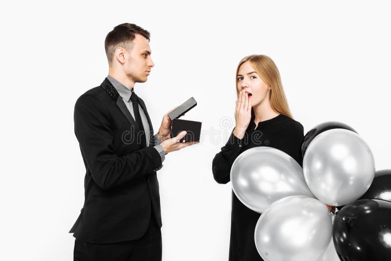 L'homme élégant dans un costume fait une proposition pour le mariage à un wh de fille photographie stock L'homme élégant dans un costume fait une proposition pour le mariage à un wh de fille photographie stock