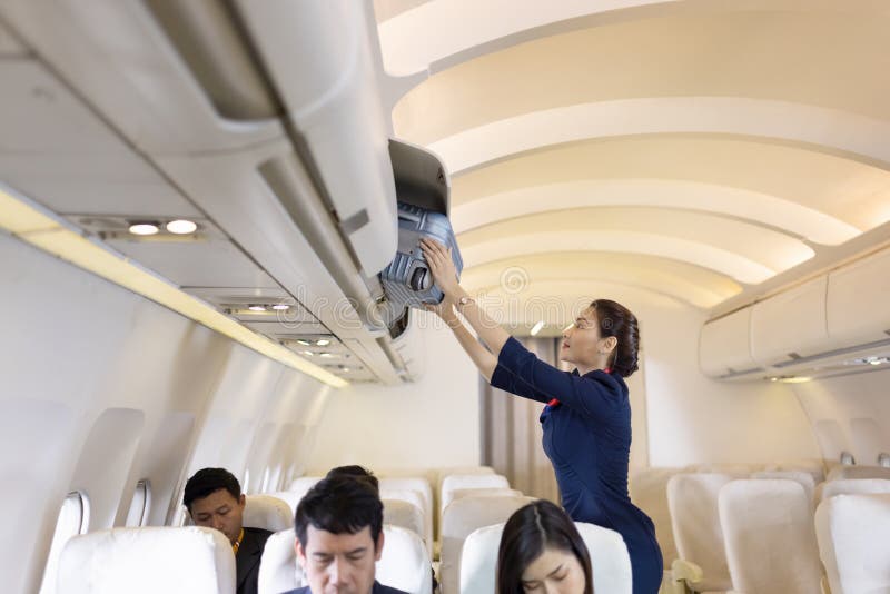 L Hôtesse Aide Les Passagers à Mettre Leurs Bagages Dans La Cabine De L Avion Hôtesse De L Air