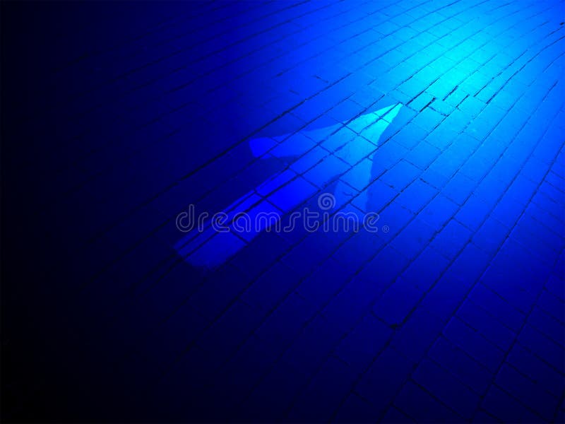 Abstract blue lighting, painted white direction sign over brick road, transportation concept. Abstract blue lighting, painted white direction sign over brick road, transportation concept