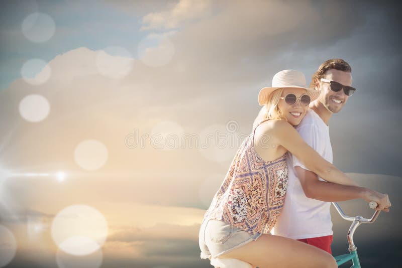 L'image composée des couples mignons sur un vélo montent l'image composée numérique photos libres de droits