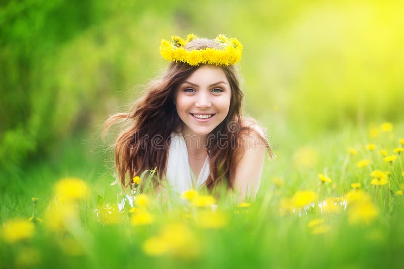 L'image de la jolie femme se couchant sur des pissenlits mettent en place, che heureux photos stock L'image de la jolie femme se couchant sur des pissenlits mettent en place, che heureux photos stock